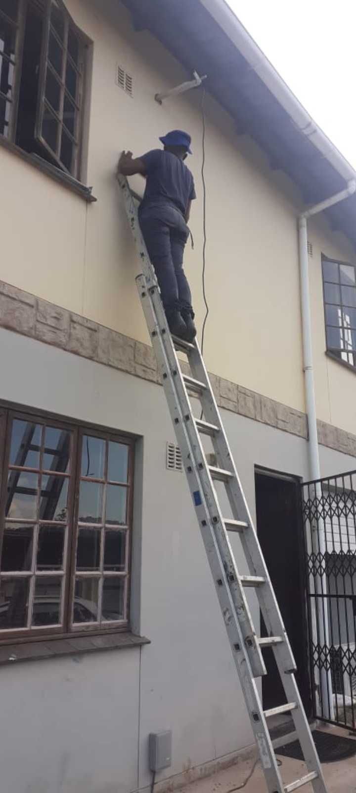 Technician working from a ladder on a residential installation